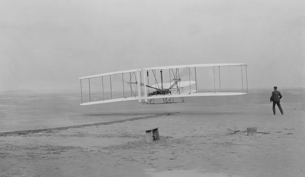 Historiallinen hetki: Orville Wright lent�� Flyer 1:ll� 17.12.1903 Wilbur-veljen seuratessa henke��n pid�tellen vierelt�.